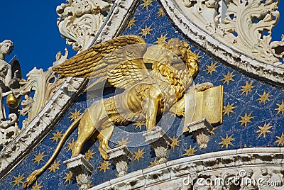 Winged golden lion decorating upper facade of the Saint Mark`s Basilica in Venice, Italy. Editorial Stock Photo