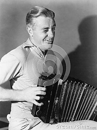 Winking man playing accordion Stock Photo