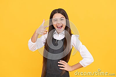 Winking school age girl child happy smile pointing finger gun hand gesture, September 1 Stock Photo