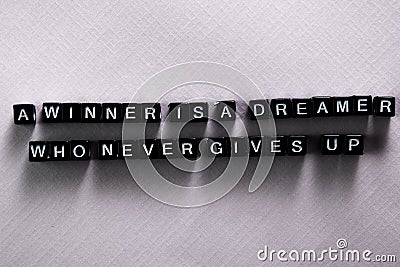 A winner is a dreamer who never gives up on wooden blocks. Motivation and inspiration concept Stock Photo