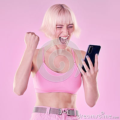 Winner, fashion and woman with phone on pink background for success, winning and online competition. Smartphone, beauty Stock Photo