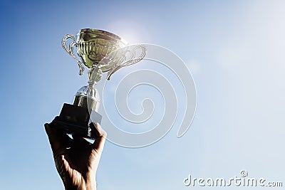 Winner holding up a first place sporting trophy cup Stock Photo