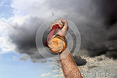 Winner raising hand with gold medal through dirt up to sky, closeup Stock Photo