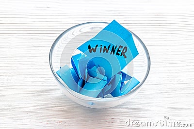 Winner selection. Paper pieces for lottery in vase on white wooden table Stock Photo