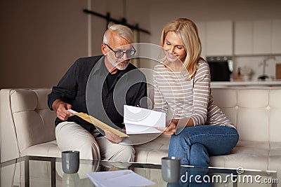 Winning the lottery. Happy mature family looks at bills. Interested in an advertising offer, increased payout Stock Photo