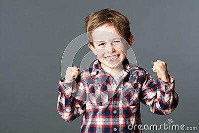 Winning young child with tooth missing raising arms for excitement Stock Photo