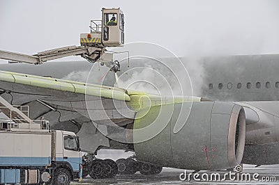 Winter at the airport. Snow storm. Airplane de-icing before take off. De-icing the aircraft before the flight. The de Stock Photo