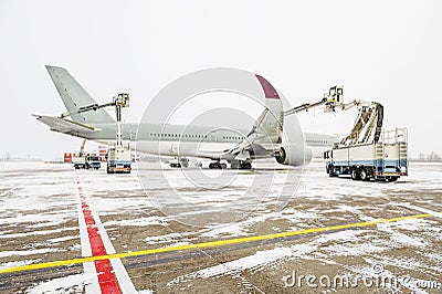 Winter at the airport. Snow storm. Airplane de-icing before take off. De-icing the aircraft before the flight. The de Stock Photo