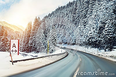 Winter alpine road curve landscape with forest, mountains and blue sky on background at bright cold sunny day. Car trip Stock Photo