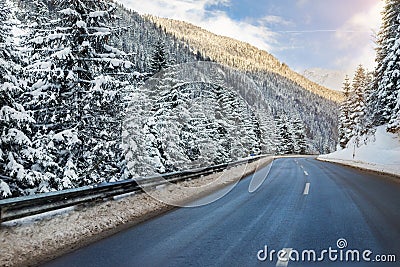 Winter alpine road curve landscape with forest, mountains and blue sky on background at bright cold sunny day. Car trip Stock Photo