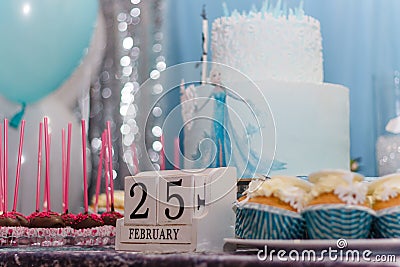 Winter birthday candy bar, muffins with Frozen cartoon characters. Cubic calender with 25th February date Editorial Stock Photo