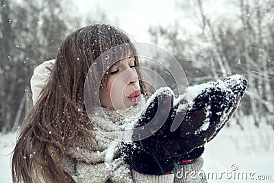 Winter blondy woman blowing snow on herself. Attractive winter woman play with snow Stock Photo