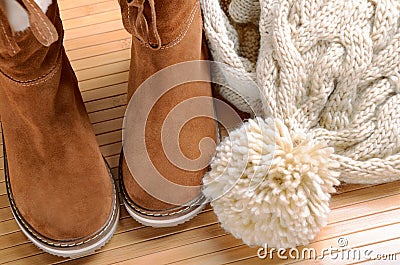 Winter boots, hat and scarf on the floor Stock Photo