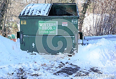 Winter Brothers trash dumpster sits empty in a snowplowed parking lot Editorial Stock Photo