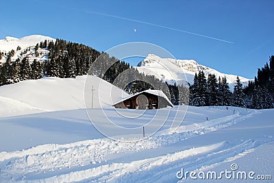 Winter Chalet House at the Mountains in Lech am Arlberg with Road, Austrian Alps Stock Photo