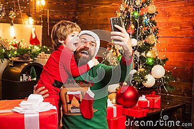 Winter Christmas emotion. Little Santa and old bearded Santa using smartphone. Internet, wireless and social media Stock Photo