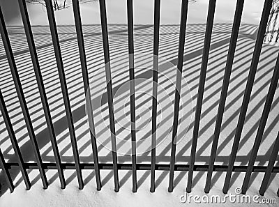 Winter cityscape. Fence and shade from the sun. Black and white photography Stock Photo
