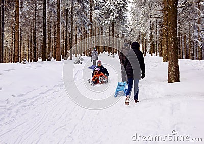 Winter day with snow and happy mother and doughter sleighing the Editorial Stock Photo