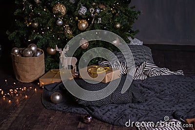 Winter decor: Christmas tree,garland, balls, gifts and cozy striped and gray plaids with pillows Stock Photo