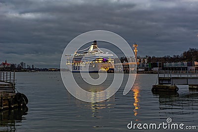 Winter evening view of South harbor embankment in Helsinki, Finland with Silja Symphony cargo-passenger cruise ferry moored at Editorial Stock Photo