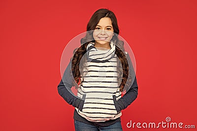 winter fashion. positive kid with curly hair in fleece jacket. teen girl on red background. Stock Photo