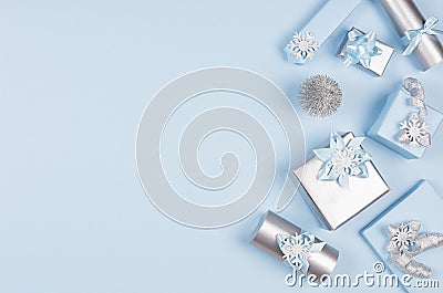 Winter festive background for advertising and design - set of blue and silver metallic gift boxes with ribbons on soft blue. Stock Photo