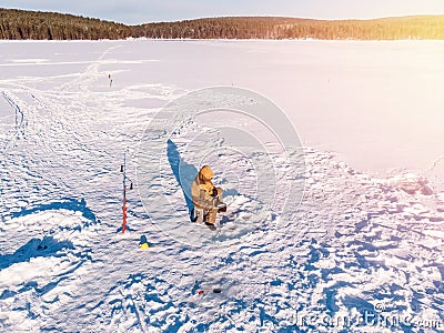 Winter fishing on ice, top aerial view, fisherman rod in hole in lake Stock Photo