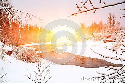 Winter forest on the river at sunset. Colorful landscape with snowy trees, frozen river with reflection in water Stock Photo