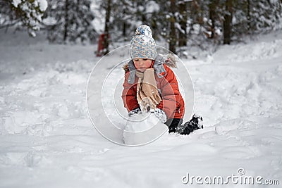 Winter fun. the boy sculpts the snowman. Stock Photo