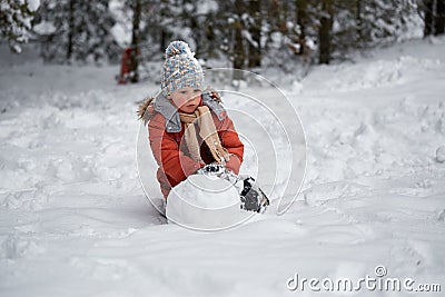 Winter fun. the boy sculpts the snowman. Stock Photo