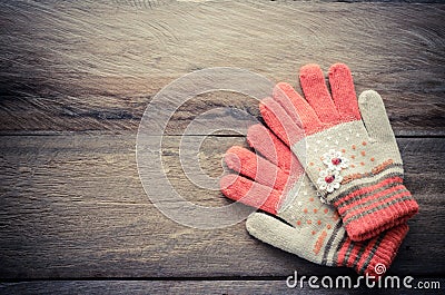 Winter gloves orange color on wooden background - tone vintage. Stock Photo