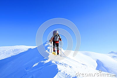 Winter hiking in the mountains on snowshoes with a backpack and tent. Stock Photo