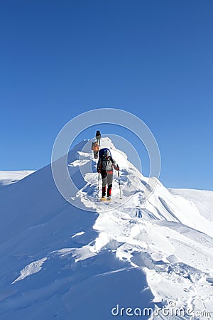 Winter hiking in the mountains on snowshoes with a backpack and tent. Stock Photo