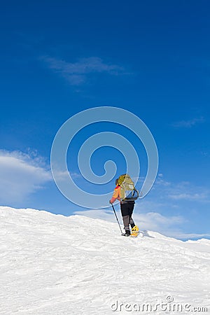 Winter hiking in the mountains on snowshoes with a backpack and tent. Stock Photo