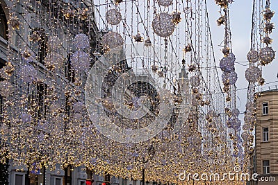 Winter holiday street with luminous festoons. Large Christmas ball from the garland glow, Christmas Stock Photo