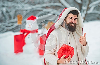 Winter holidays and people concept. Snowman and funny bearded man with gift - the friends. Happy father with Christmas Stock Photo