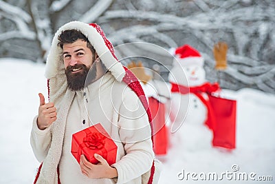 Winter holidays and people concept. Snowman and funny bearded man with gift - the friends. Happy father with Christmas Stock Photo