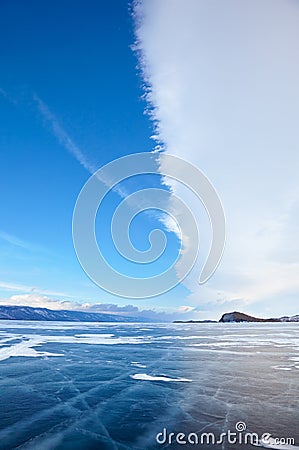Winter ice landscape on lake Baikal with dramatic weather clouds Stock Photo