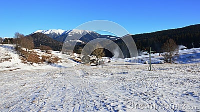 Winter landscape on Donovaly Snow Park with empty downslope for skiing, mountains of Little Fatra in background. Stock Photo