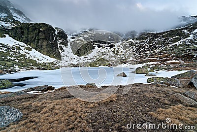 Winter landscape ice lake snow rock storm sky Stock Photo