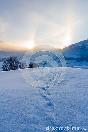 Snowy winter landscape in the alps, sunrise with halo phenomena Stock Photo