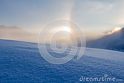 Snowy winter landscape in the alps, sunrise with halo phenomena Stock Photo