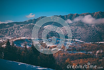 Winter landscape with snow-covered hills and mountains. Human settlements in wild areas Stock Photo