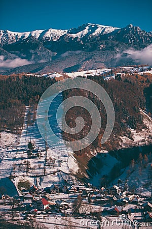 Winter landscape with snow-covered hills and mountains. Human settlements in wild areas Stock Photo