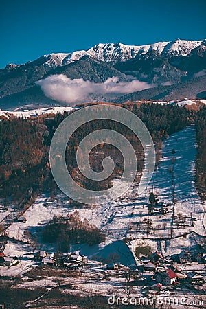 Winter landscape with snow-covered hills and mountains. Human settlements in wild areas Stock Photo