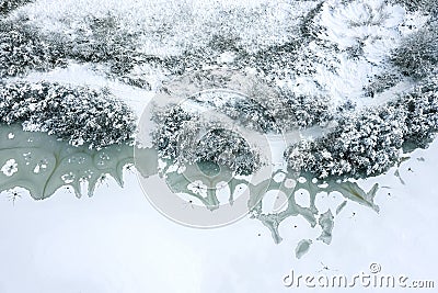 Winter landscape with snowy riverbank and river covered with cracked ice and snow. aerial top view Stock Photo