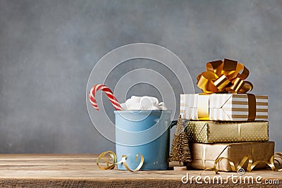 Winter lifestyle with cup of hot cocoa with marshmallows and Christmas gift or present boxes and holiday decorations Stock Photo