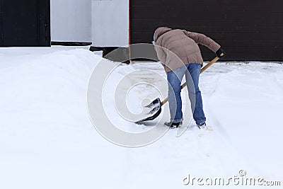Winter is a lot of snow. A young girl, cleans, proud of doing the big shovel work Stock Photo