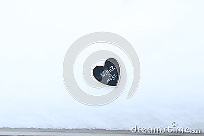 Winter is Magic idea. Heart with an inscription in the snow. Stock Photo