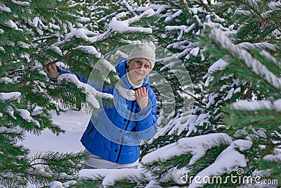 Winter mood. A woman in a blue jacket looks at the camera. The Walk Is December January February. Stock Photo